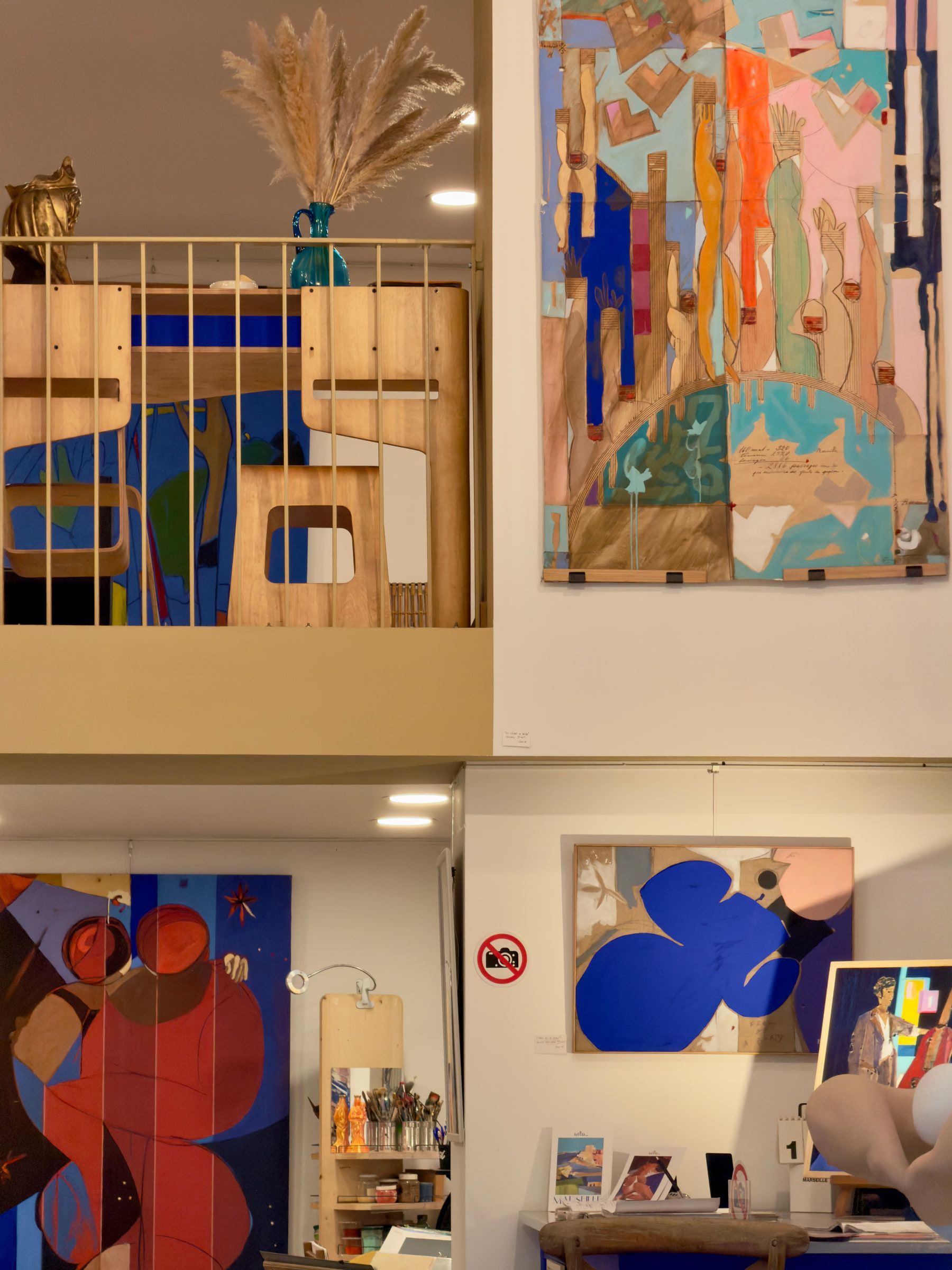 The interior of a gallery over two levels, hung with large abstract paintings in blue, red and orange
