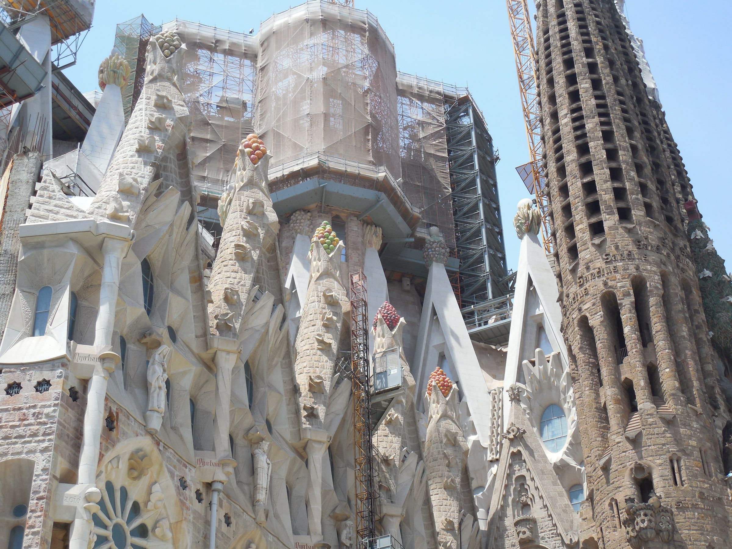 Basilica towers under construction, wrapped in scaffolding with a crane standing alongside